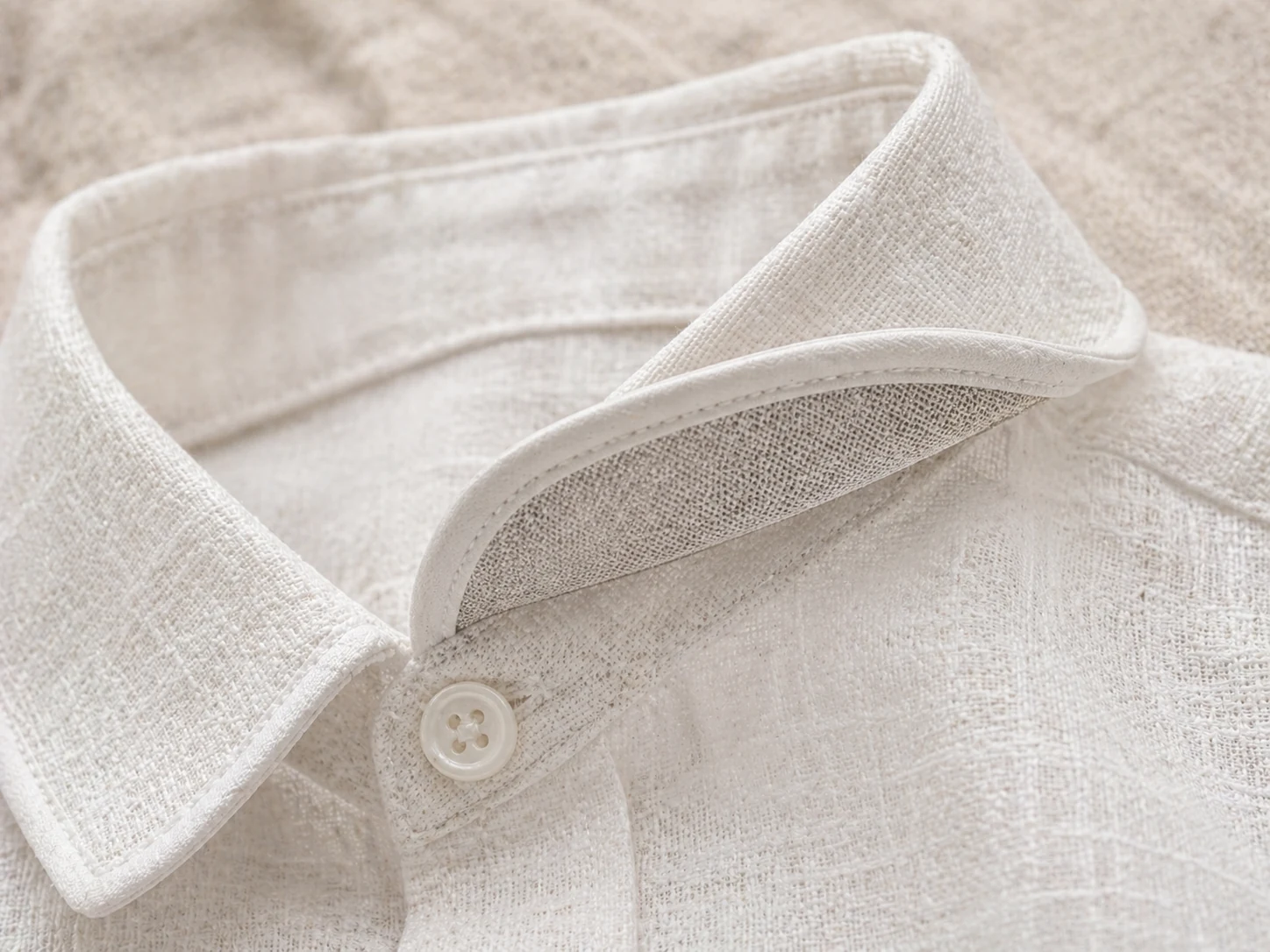 Macro do colarinho turn-down da Camisa Social em linho off-white · entretela aplicada de um lado só · acabamento institucional